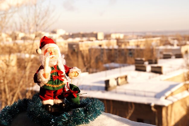 Toy Santa Claus in red clothes with a candle in a hand