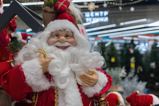 Toy Santa Clauses in the store against the background of garlands Christmas decorations