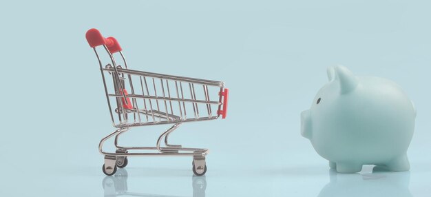 Toy shopping cart and Piggy bank. Consumer society trend