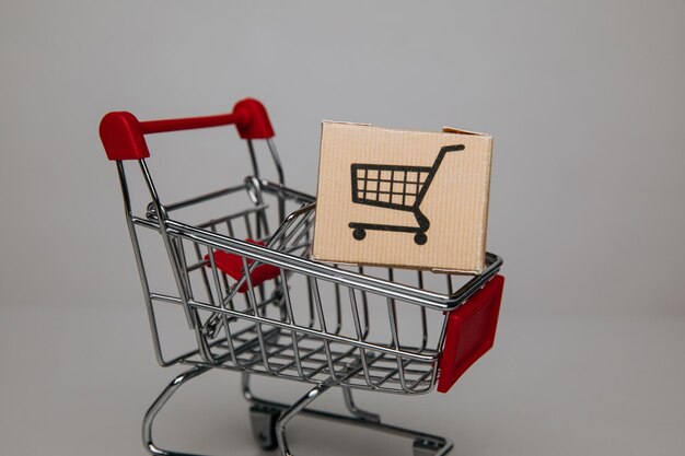 Toy shopping cart with box closeup Sale discount shopping and delivery concept