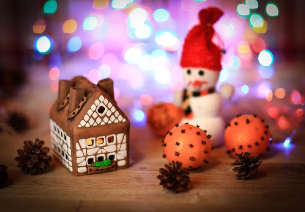 Toy snowman and gingerbread house at the christmas table