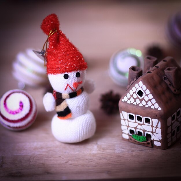 Toy snowman and gingerbread house at the christmas table