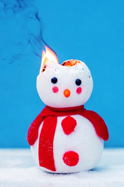 Photo a toy snowman is on fire fire for the new year