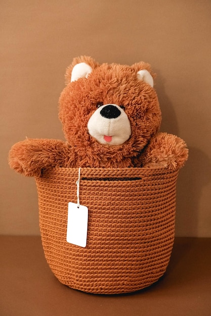 Toy teddy bear with a knitted bag on a brown background Copy empty space for text