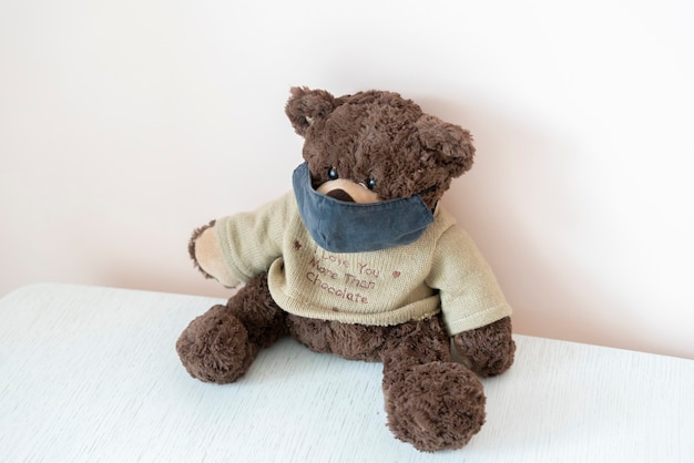 a toy teddy bear with a protective face mask, concept of coronavirus epidemic