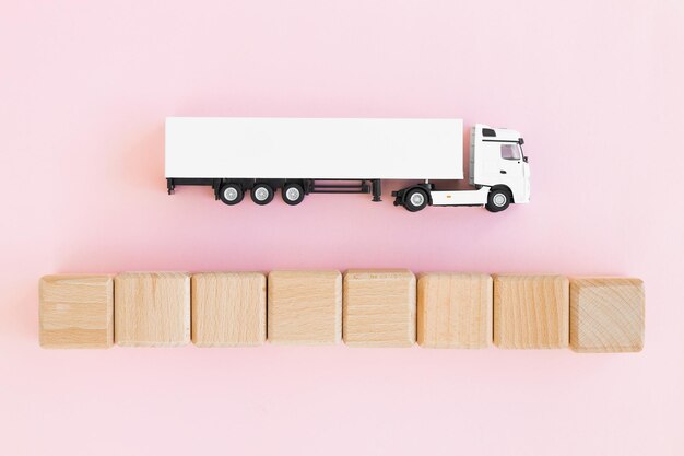 사진 분홍색 물류 및 도매 개념에 격리된 나무 큐브가 있는 장난감 트럭