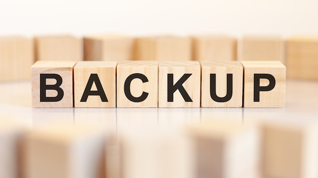 Toy wood blocks with letters backup on a table with light
background, selective focus. toy blocks around.