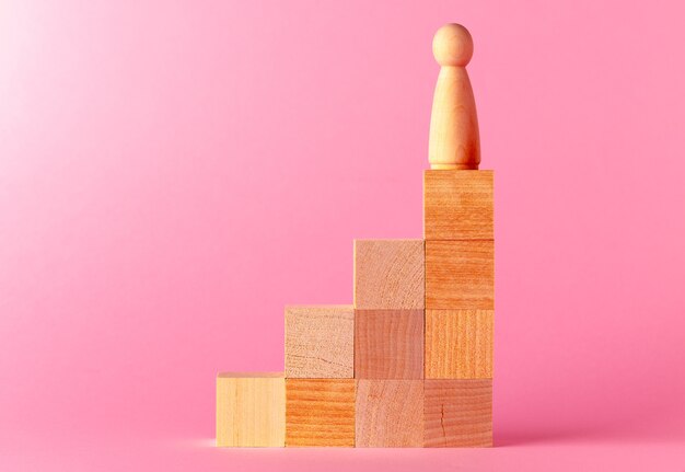 Toy wooden cubes against pink background