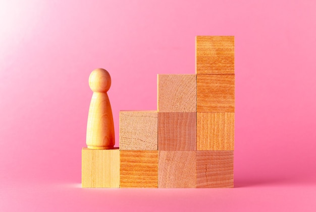 Toy wooden cubes against pink