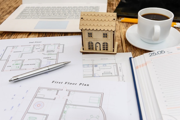 toy wooden house with draft, organiser and laptop