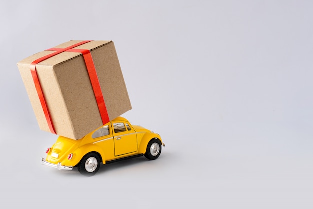 toy yellow car is carrying a parcel.