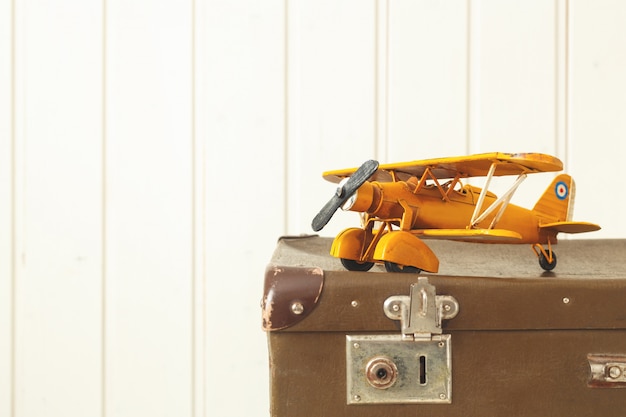 Toy yellow metal plane Old retro suitcases White wood Vintage tinting