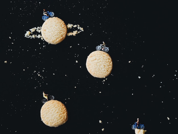 Photo toys on cookies against black background