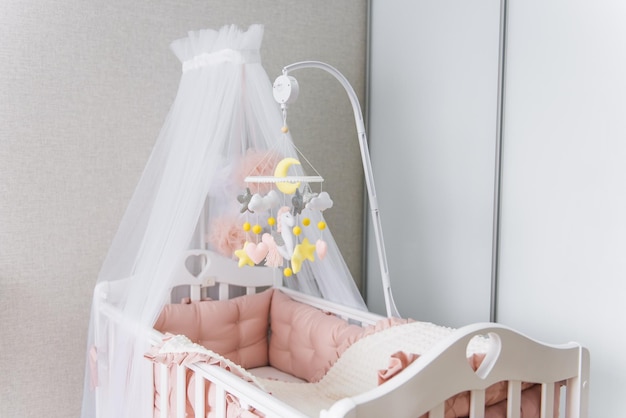 Toys over the crib A mobile baby cot with stars clouds and a unicorn