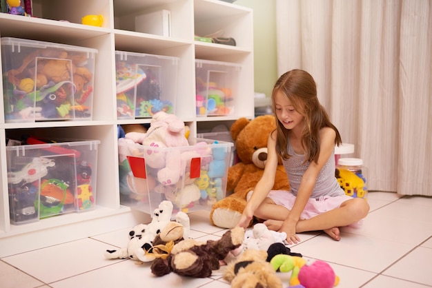 たくさんのおもちゃ部屋でおもちゃで遊ぶ少女のショット