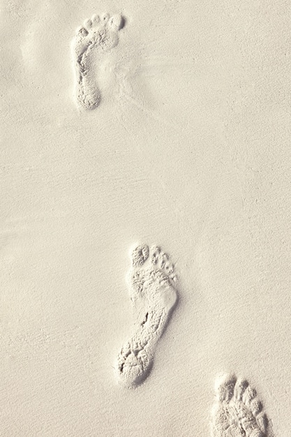 몰디브 열대 섬의 모래에 맨발의 흔적.