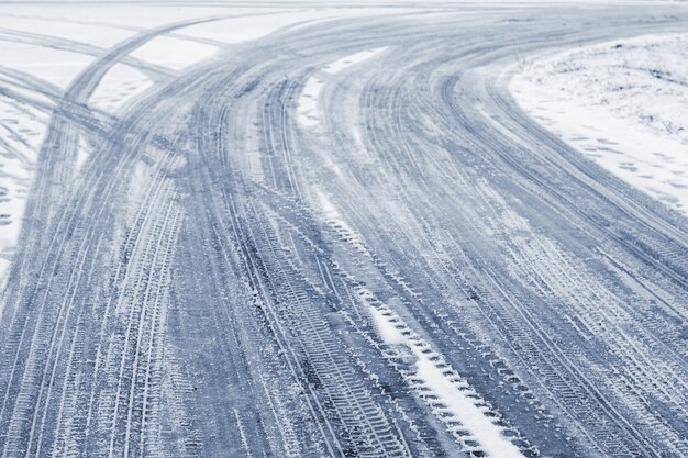 Traces of the car on a snowy road in winter