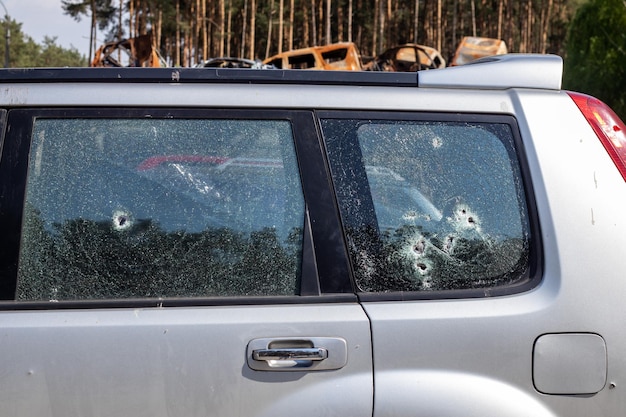 Foto tracce di colpi sul corpo dell'auto guerra tra russia e ucraina parte di un'auto civile a cui hanno sparato durante l'evacuazione di persone disarmate dalla zona di combattimento