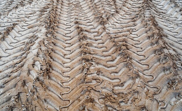 Traces of tractor tires in the sand in an industrial zone