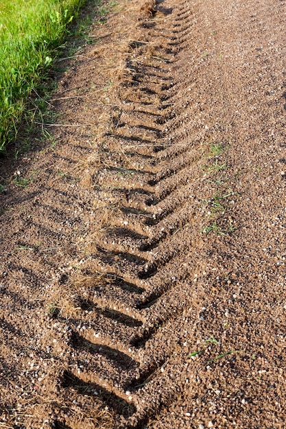 Traces of tractor or truck wheels on the sand after rain