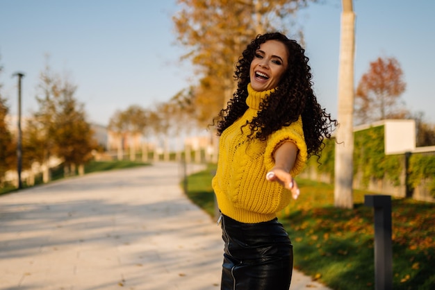 On the track in the park sings actively putting forward one hand with a wide open mouth curly brunet