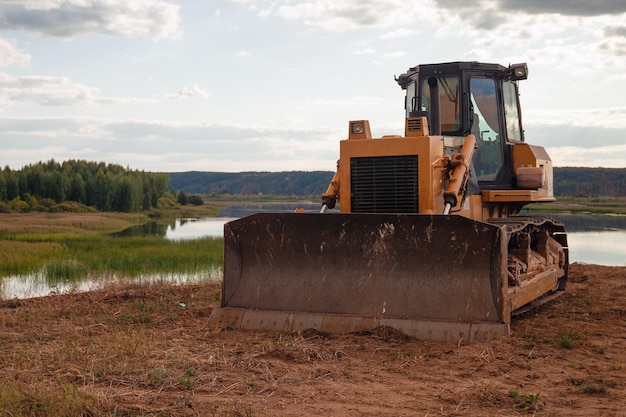 Photo tracked tractor on background of forest lake