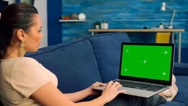 Tracking shot van freelancer vrouw typen op groen scherm chroma key laptopcomputer voor marketingideeën