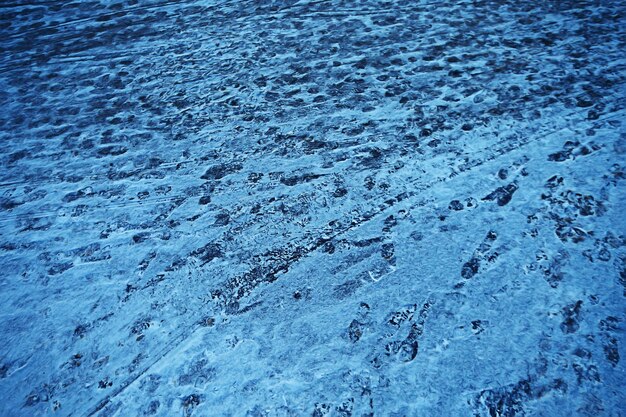 アスファルトの雪、氷、雪の上の靴からの人々のトラック、除雪の天気を追跡します