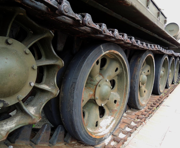 Tracks and rollers of a tracked tank packed with sand with traces of rust