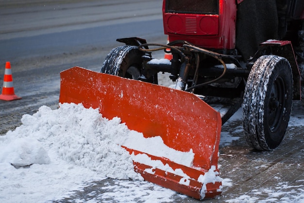 雪から道路を掃除するトラクター。掘削機は、市内の大量の雪の通りを掃除します。