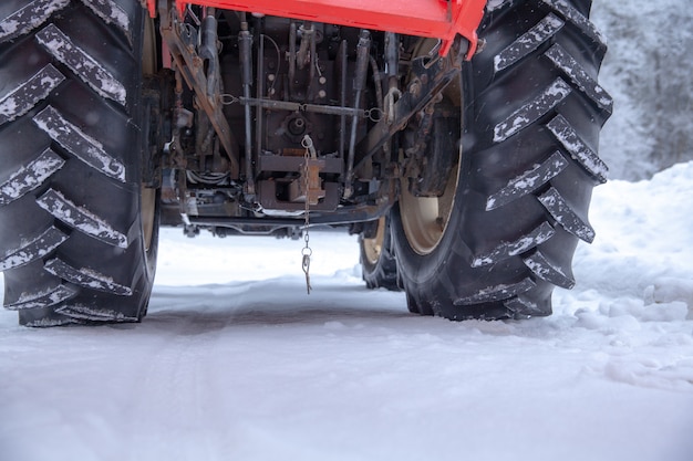 Photo tractor cleans road from snow in the winter