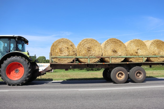 Tractor collects hay and takes it to the farm