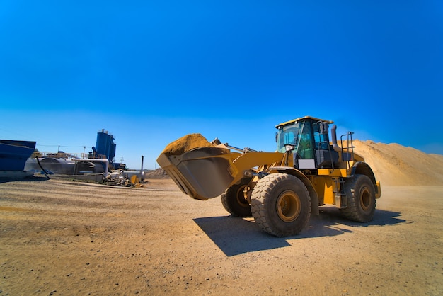 The tractor collects a scoop with gravel. excavator extracts sand and gravel for the concrete mix