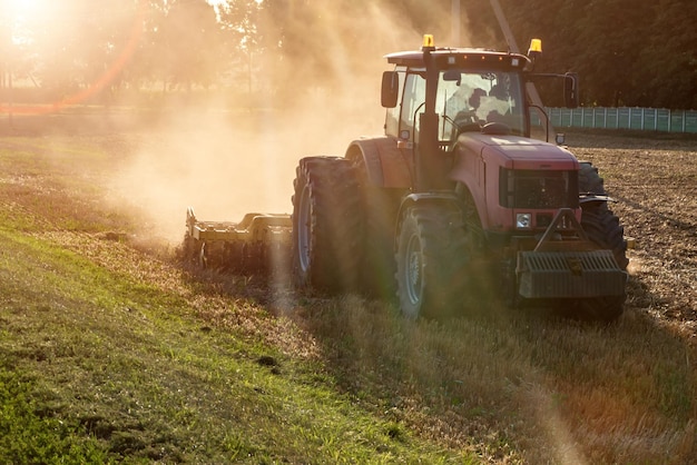 Tractor cultivator plows the land prepares for crops dust on field