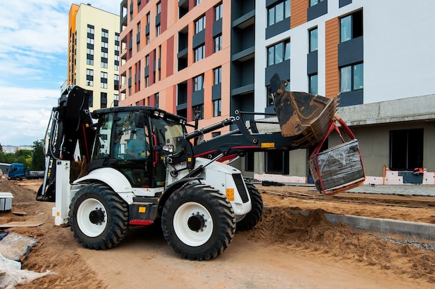 tractor egaliseert de grond voor de aanleg van een nieuwe weg in de zomer