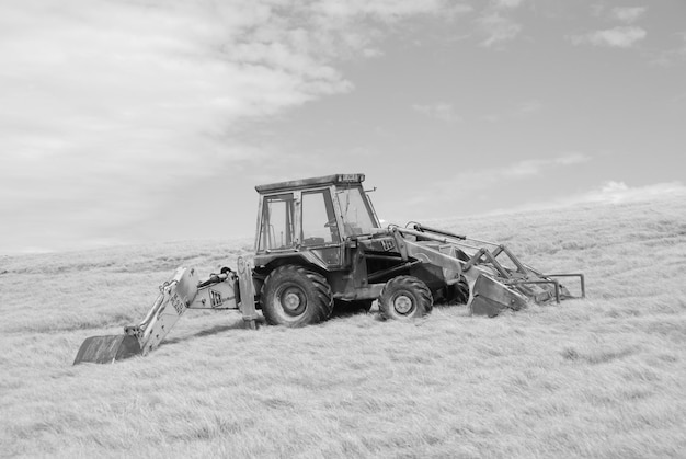 tractor in field against cloudy sky