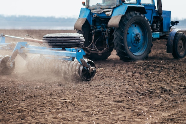 Tractor on the field farming in the village and village sowing in the spring agronomist on a combine