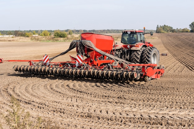 The tractor harvester working on the field