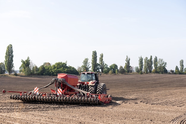 The tractor harvester working on the field