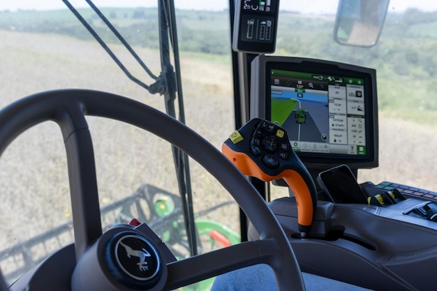 Foto tractor che raccoglie soia in una fattoria in brasile visto dall'interno della cabina