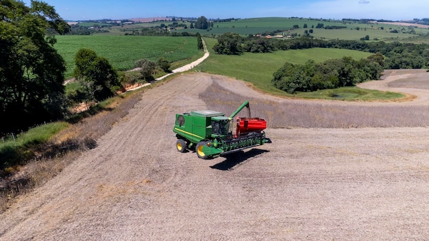 Трактор собирает соевые бобы на ферме в Бразилии