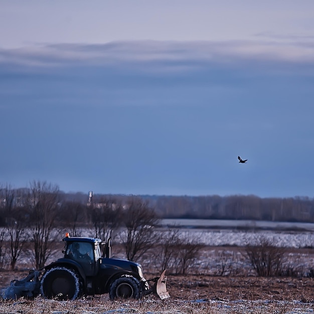tractor in het veld bouwland winter agribusiness landschap seizoenswerk in een besneeuwd veld