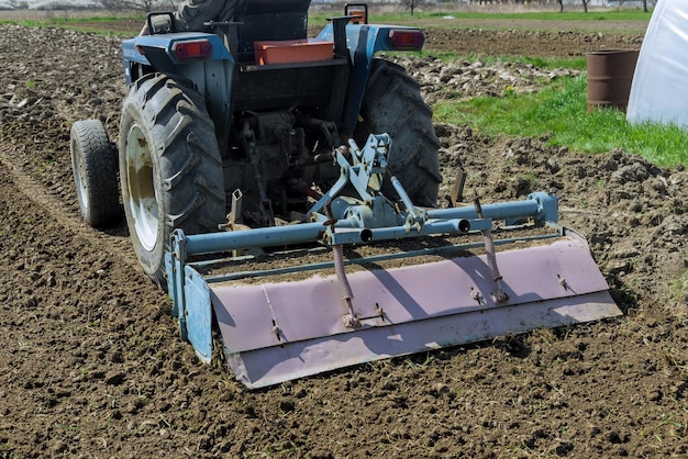 Tractor loosens and cultivates soil on field