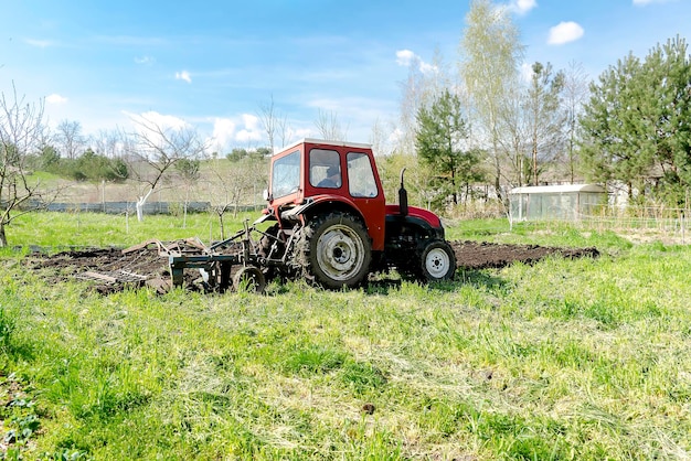 Tractor machinery plowing agricultural field meadow at farm at spring autumnFarmer cultivating make soil tillage before seeding plants crops nature countryside rural scene