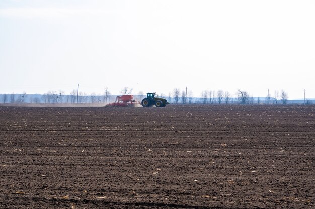 Tractor met zaaimachine in het veld in het vroege voorjaar