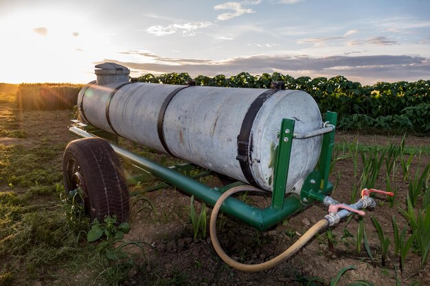Tractor op het veld tegen de hemel bij zonsondergang
