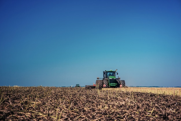 Tractor plowing farm field in preparation for spring planting.