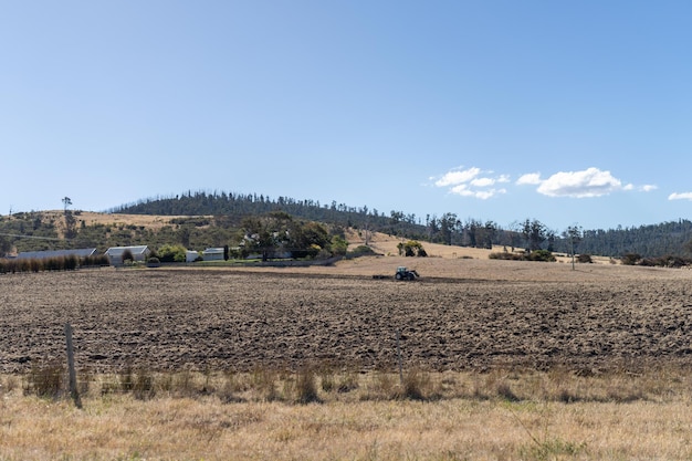 tractor plowing a field in a dry hot summer farming landscape australia