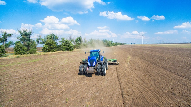 A tractor plowing and sowing in the field