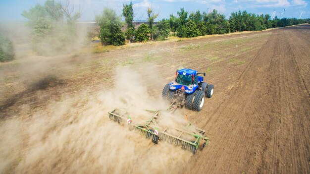 A tractor plowing and sowing in field